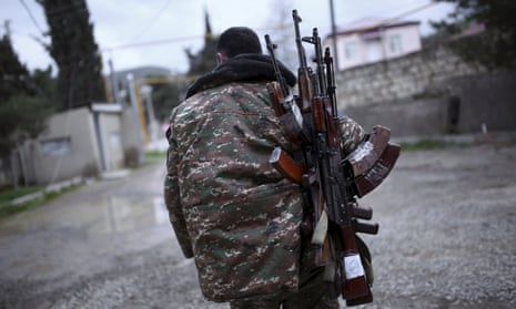 An ethnic Armenian soldier carries weapons in Martakert province, Nagorno-Karabakh.