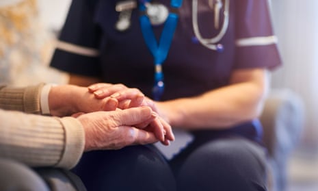 A nurse holding a senior patient's hand