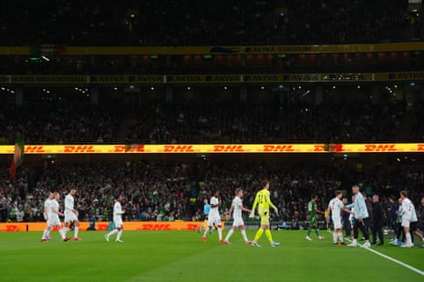 Republic of Ireland and Austria players walk off the pitch after tennis balls with stickers of the Palestine flag are thrown by the crowd.