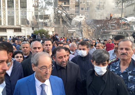 Syrian Foreign Minister Faisal Mekdad walks near a damaged site after what the Iranian media said was an Israeli strike on a building close to the Iranian embassy in Damascus, Syria.