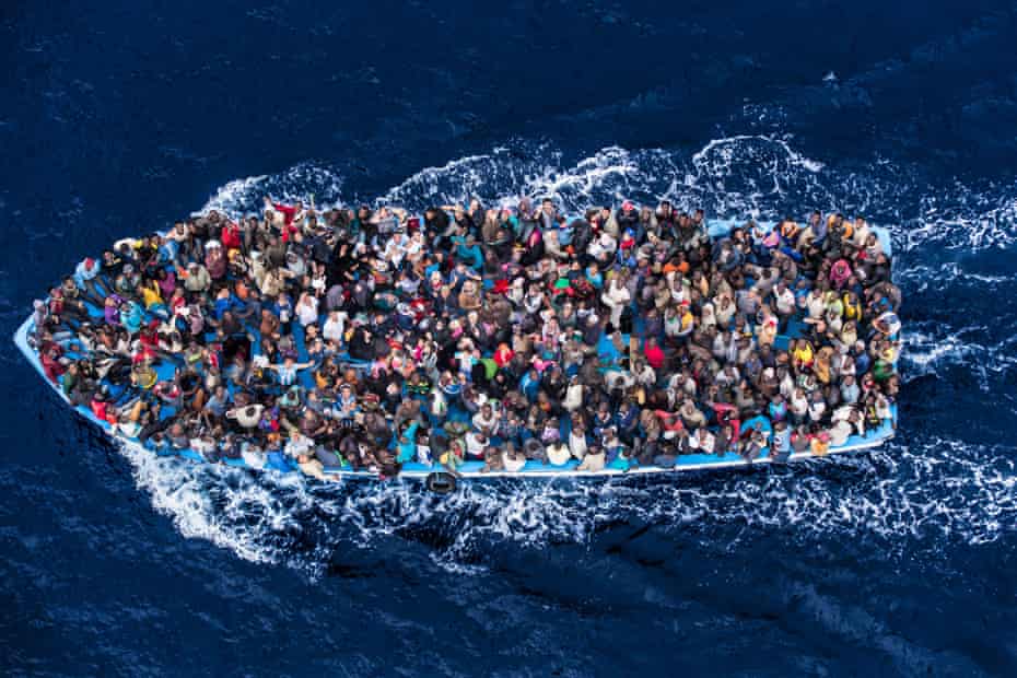 Migrants risk everything for a new life in Europe. African asylum seekers photographed from an Italian navy helicopter shortly before being rescued on the Mediterranean Sea. 8 June 2014.