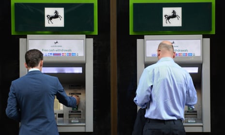 Two men use ATMs