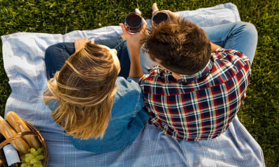 A couple enjoy a day in the park making a picnic.