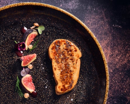 Gourmey cultivated foie gras on a black plate with figs
