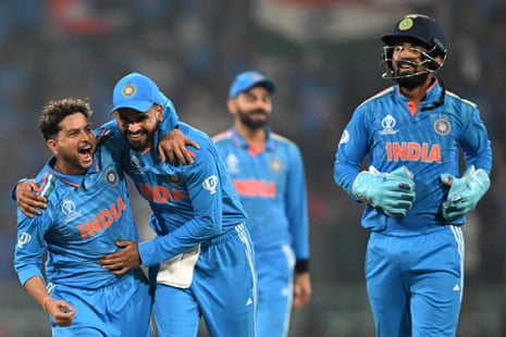 India's Kuldeep Yadav (L) celebrates with teammates after taking the wicket of England's captain Jos Buttler.
