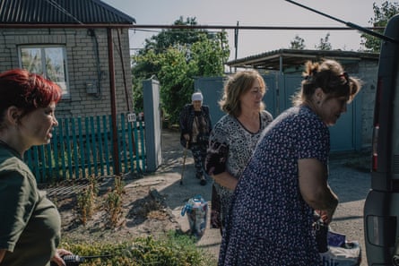 Yuliia Sokol helps evacuate Liudmyla, 86, and her daughter Maria (right).