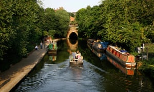 Canal boat sailing up the Regent’s canal towards Islington Tunnel.