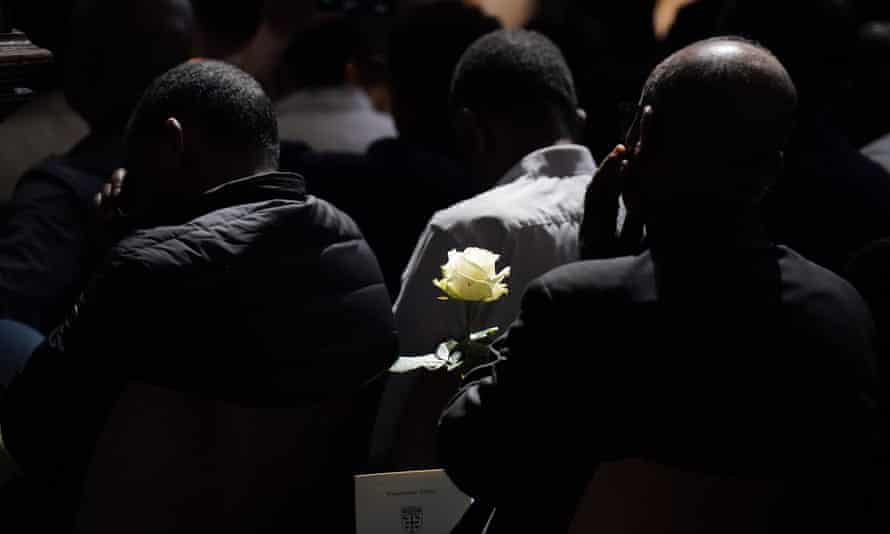 A member of the public holds a white rose during the memorial service