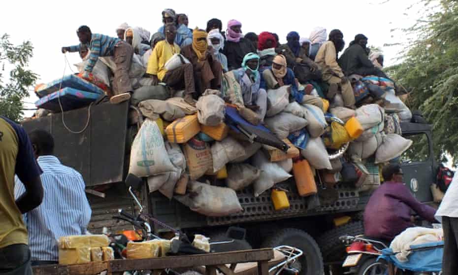 Migrants sit on top of a truck about to leave the city of Agadez in Niger