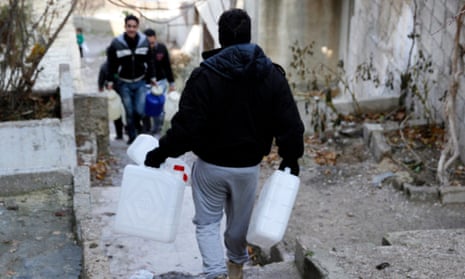 A man carries empty jerry-cans to be filled with water in Damascus, Syria