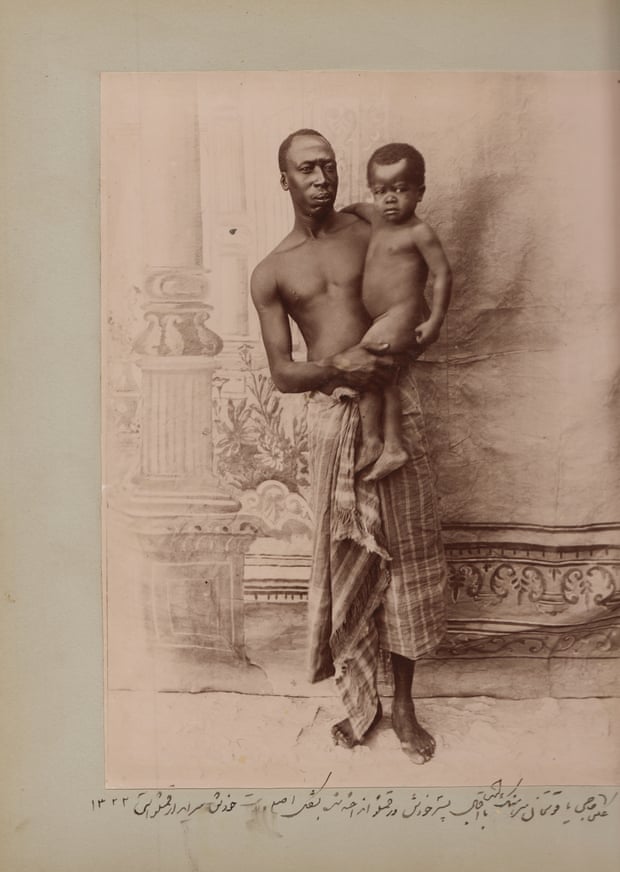 In this staged photo taken by Zell-e Soltan at his summer hunting palace near Isfahan, one of his African slaves holds his son. According to the caption, the infant (Iqbal) is the real son of the adult African slave, Haji Yaqut Khan, suggesting he wasn’t a eunuch and could father his own children. The caption says that Yaqut Khan is in his ethnic clothes (languteh), which was mainly worn by Africans outside of Iran, 1904.