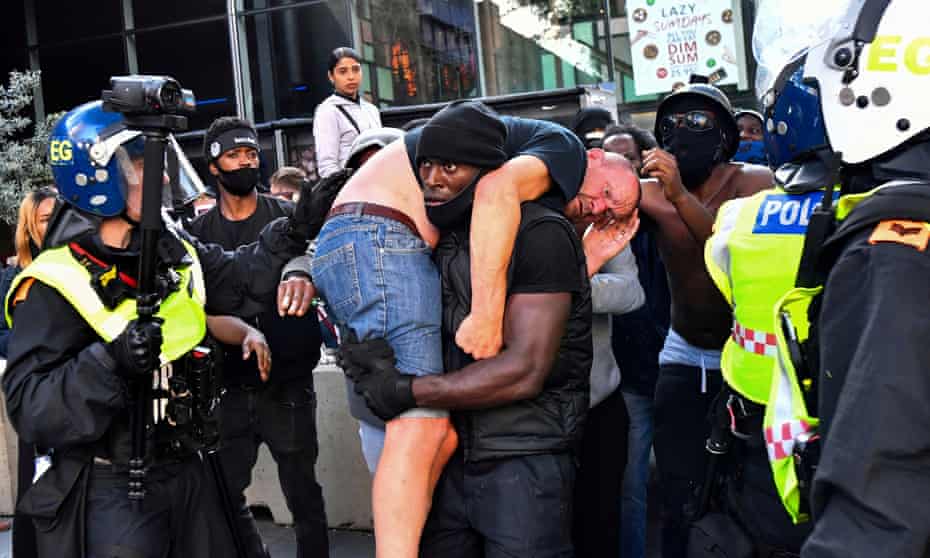 Patrick Hutchinson carries an injured counter-protester to safety, near Waterloo station during a Black Lives Matter protest.