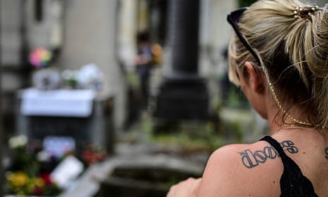 A woman stands at the grave of the Doors frontman Jim Morrison at the Pére-Lachaise cemetery in Paris.