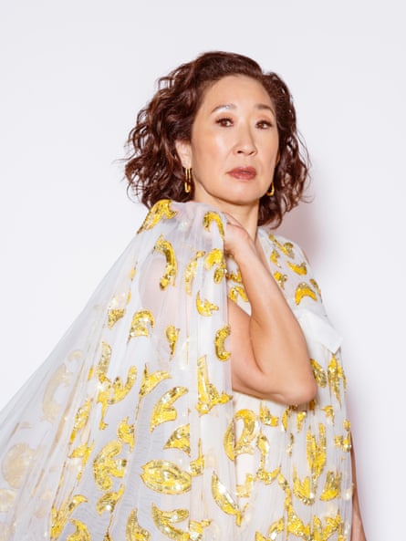 Oh wears a white dress with yellow sequin details