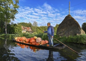 Lehde, Germany. Harald Wenske crosses a river in a Spreewald barge fully loaded with pumpkins grown in his field