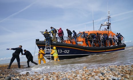 Immigration enforcement officers and members of the RNLI assist a group of people thought to be migrants from a lifeboat in Dungeness, Kent, on 23 September. 