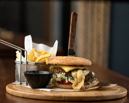 A cheeseburger and chips on a wooden platter
