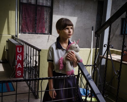 Nine-year-old-girl on an apartment block landing hold a stuffed toy animal