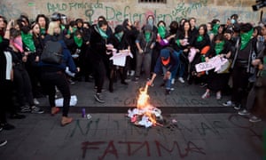 Demonstrators start a fire as they gather outside the national palace in Mexico City, Mexico, on 18 February to protest gender violence. 