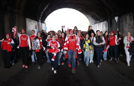 Fans of Arsenal show their support as they make their way to the stadium