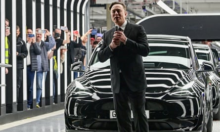 Elon Musk showing off a car at the Tesla factory