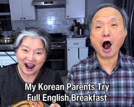 A man and a woman in a kitchen. The words ‘My Korean Parents Try Full english Breakfast’ are overlaid.