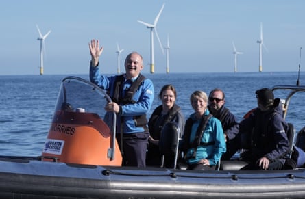 Ed Davey and other Lib Dem MPs on a speed boat with a wind farm in the background.