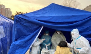 Medical worker collects a swab from a woman for nucleic acid testing in Beijing