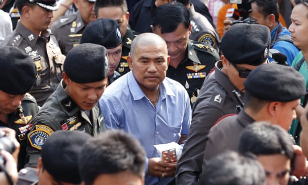 Suriyan Sucharitpolwong in October, being escorted to a court hearing