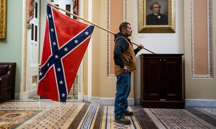 A Capitol rioter stands outside the Senate chamber.