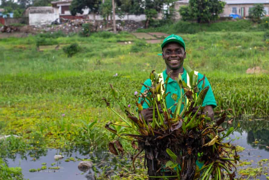 Divin Kouebatouka with a water hyacinth.