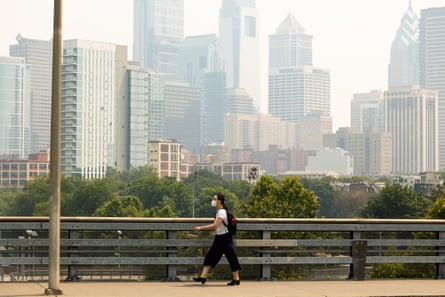 A pedestrian wears a face mask when smoke from Canada wildfires blanketed Philadelphia in June 2023. Experts recommend wearing an N95 mask on bad air days.