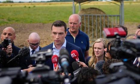 Jordan Bardella speaks to reporters at a farm