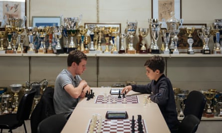 Boys play in front of an array of trophies.