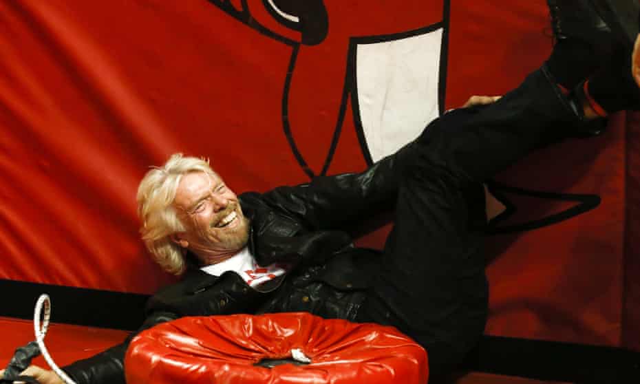Sir Richard Branson laughs as he crashes into a padded barrier while participating in a human bowling ball at an event in Atlanta.