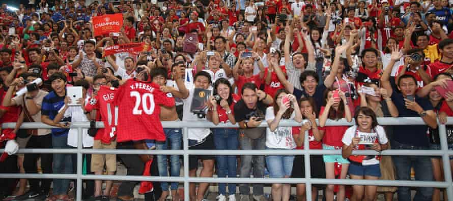 Manchester United fans watch the team train in Bangkok in 2013 during the club's last visit to Thailand.