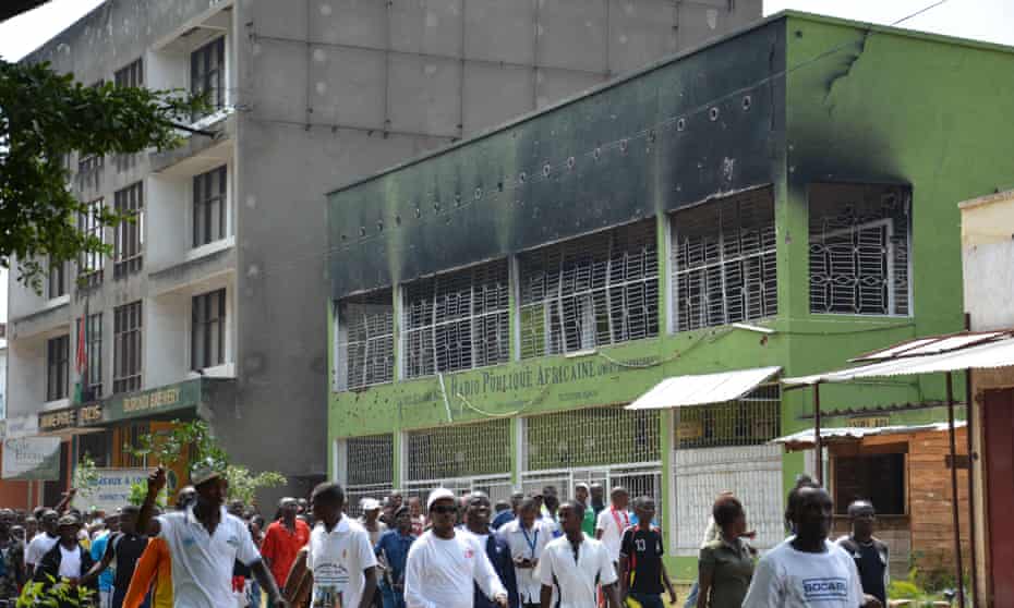 Demonstrators march last year in Bujumbura during a protest in front of the building of Radio Publique Africaine burnt in May 2015 during the failed coup.
