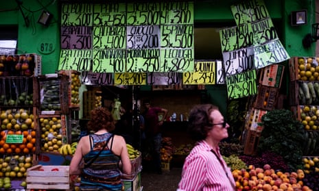 People walk by a greengrocer on Wednesday in Buenos Aires, Argentina. Official inflation rate hits 102.5% in the last 12 months, the worst figure since 1991.