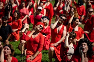 Men and women dressed in red dance in the open air