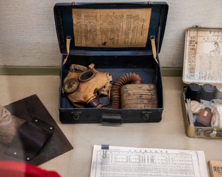 A gas mask in a case with printed instruction sheets.