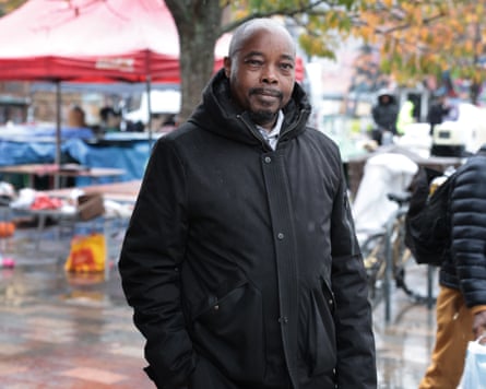 ‘You feel obligated’: African workers on the pain – and pride – of the ‘black tax’ Kimere in a black coat in a rainy urban setting