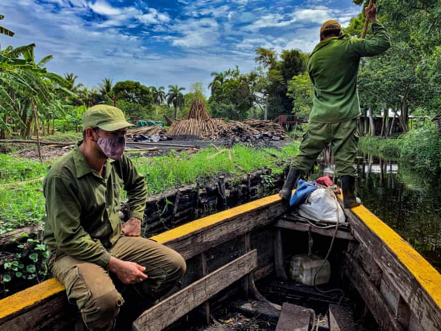 Charcoal producers navigate a channel in search of wood