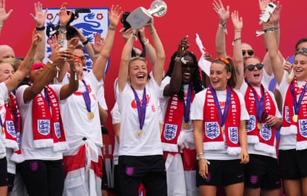 Leah Williamson lifts the trophy on stage alongside her teammates