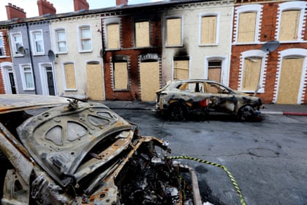 Burned cars and blackened walls of houses on 12 June after rioting in Belfast, Northern Ireland.