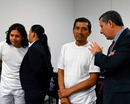 Two men in white speak with lawyers