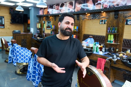 Abbasi, leaning on a barber’s chair, gestures as he speaks