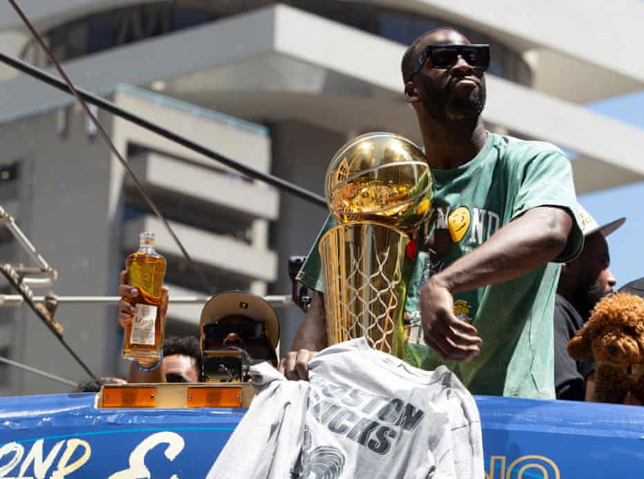 Draymond Green holds up a 'Boston Sucks' T-shirt during a parade for the NBA champions in San Francisco on Monday.