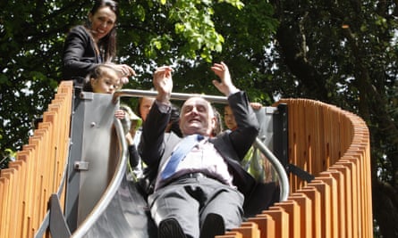 Jacinda Ardern watches as speaker Trevor Mallard rides down a children’s slide at the opening of a play area in the grounds of parliament in late 2019