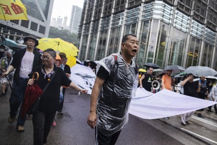 Jimmy Lai holds a banner as he marches along Queen’s Road Central during a 2019 protest.