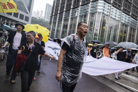 Jimmy Lai, center, holds a banner as he marches along Queen’s Road Central during a protest in the Central district of Hong Kong, China, on Sunday, Aug. 18, 2019.